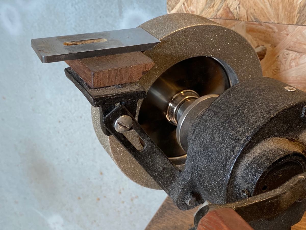 A CBN wheel mounted on Rafael's hand-cranked grinder, with a plane blade on the tool rest