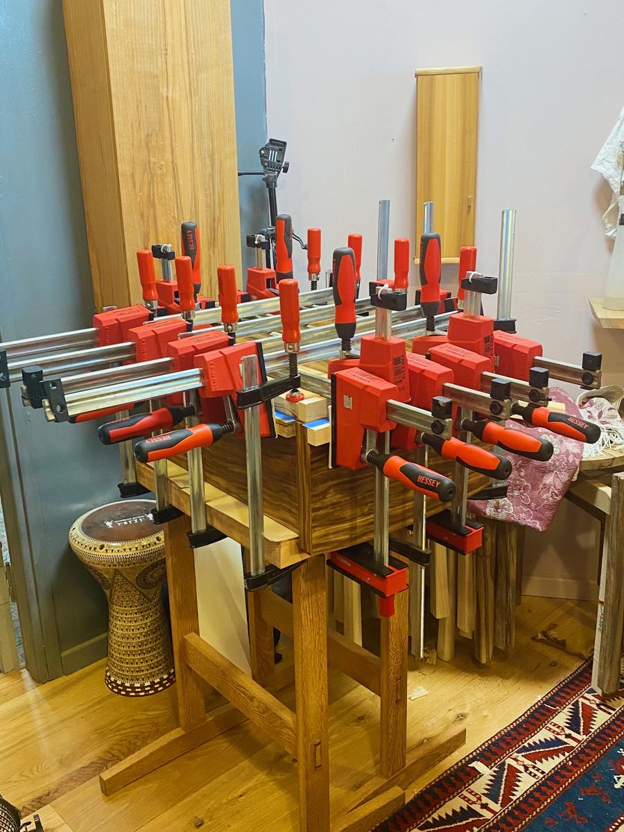 The back of a cabinet glued up under many red Bessey clamps