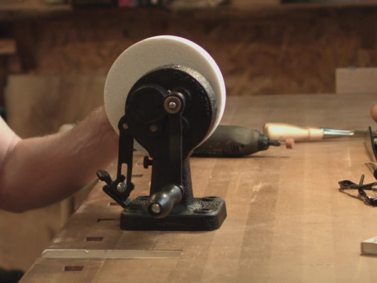 Rafael's hand-cranked grinder on the bench, with a full white wheel