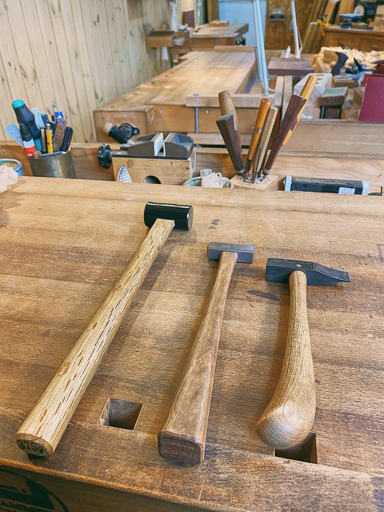 Three hammers lying on a workbench