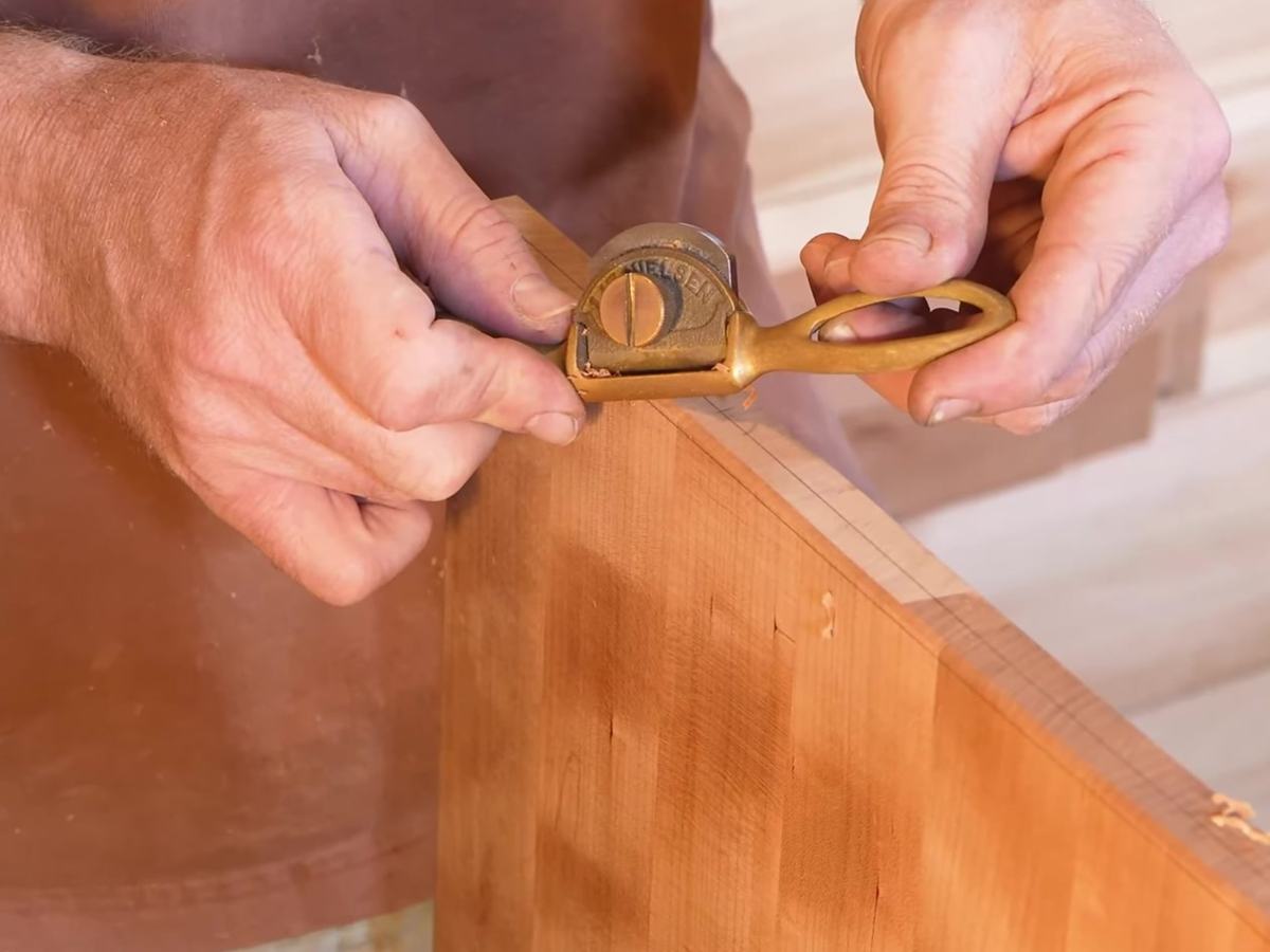 Rafael working the edge of a board with a small bronze Lie-Nielsen spokeshave